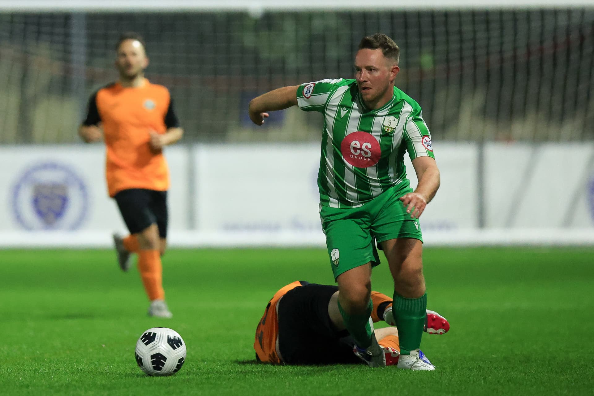A Reserves player beating a sliding challenge under the lights
